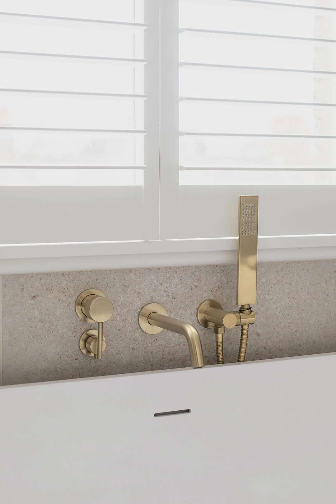 brushed-brass-hand-shower-tapware-over-white-bath