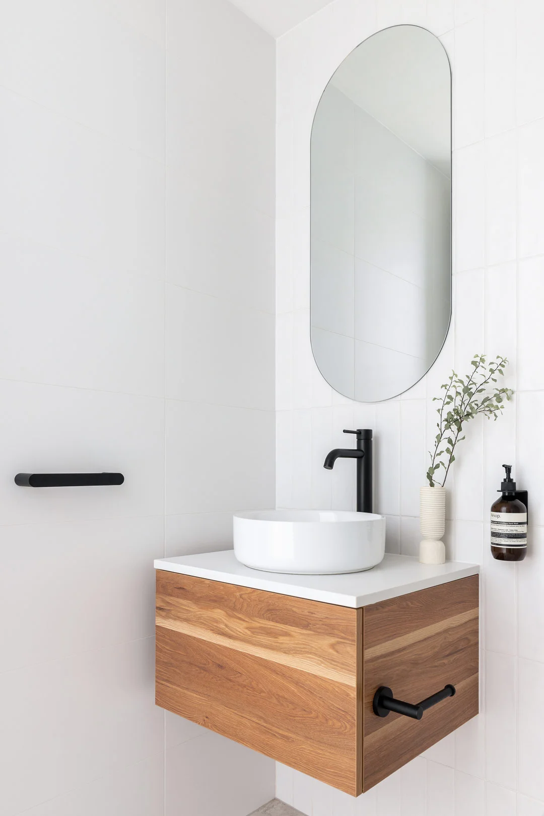 Modern coastal bathroom with matte black tapware and a timber vanity