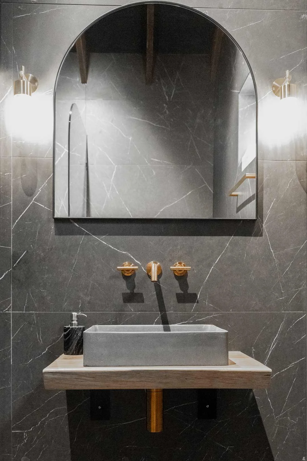 Nero-Marquina-marble-powder-room-feature-wall-with-copper-tapware