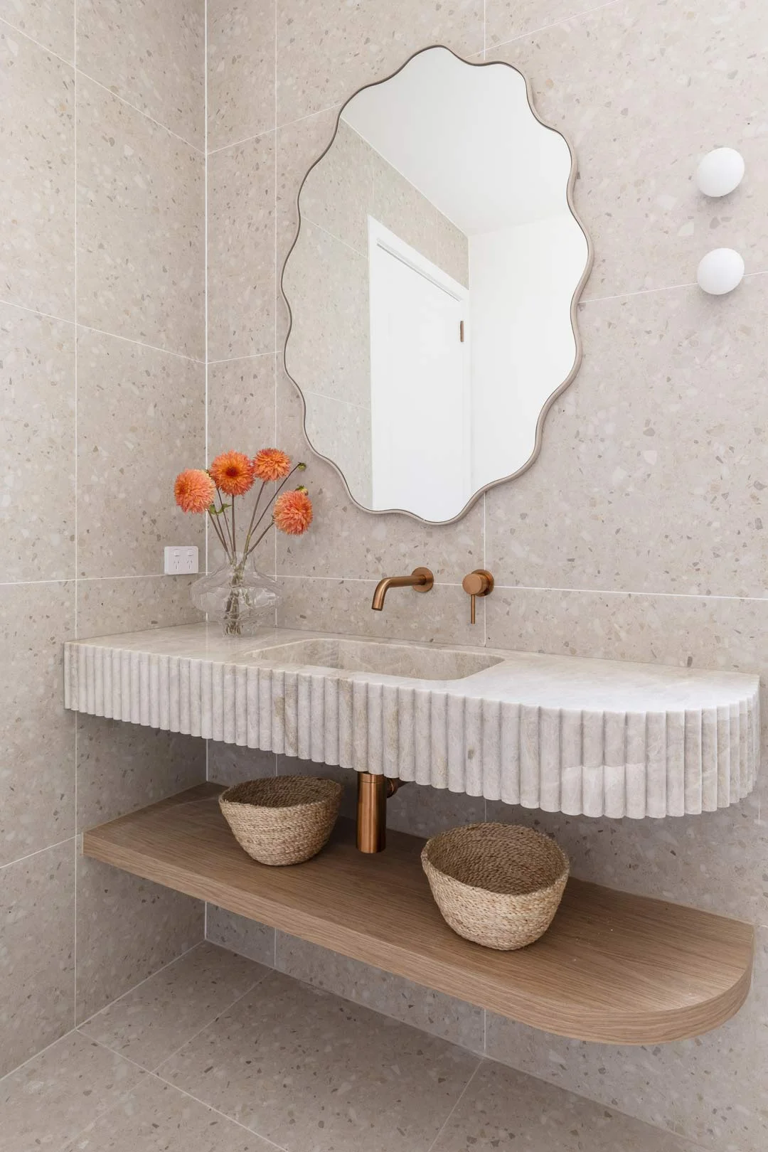 wavy mirror in neutral bathroom marble fluted scalloped vanity