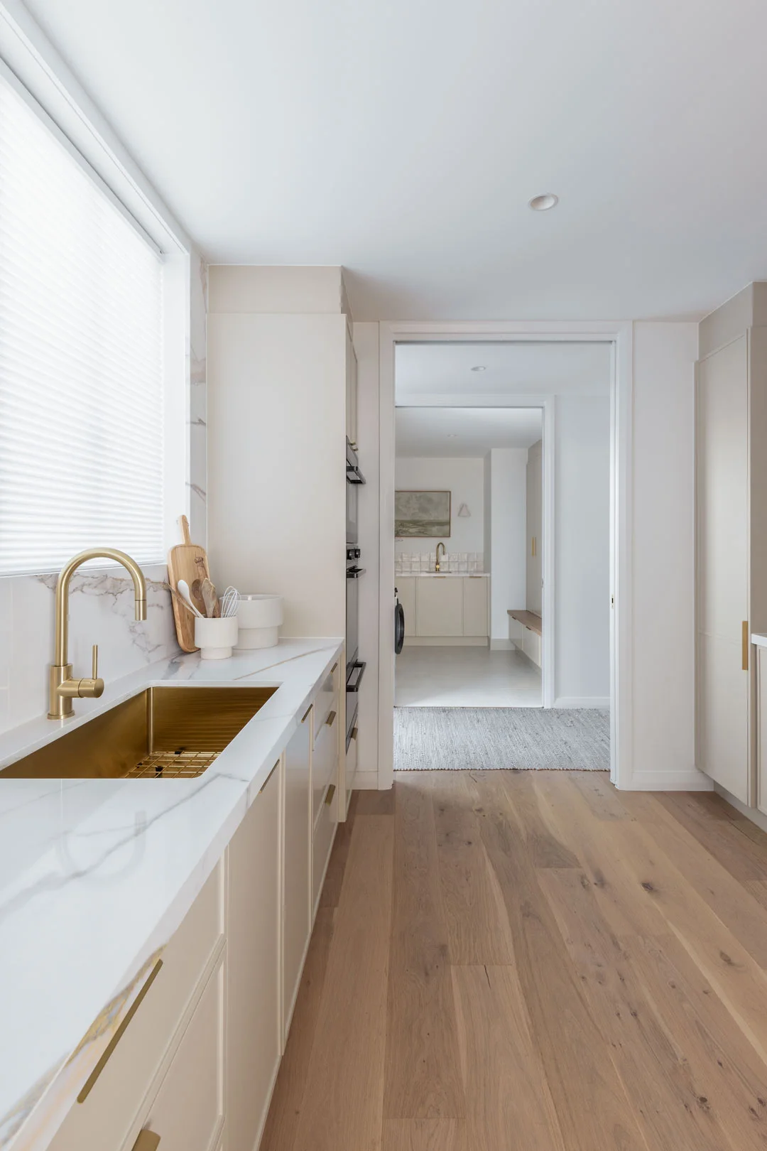 Brushed-brass-sink-and-tapware-warm-this-modern-coastal-home-designed-by-Deb-and-Andy-from-DNA-of-Design