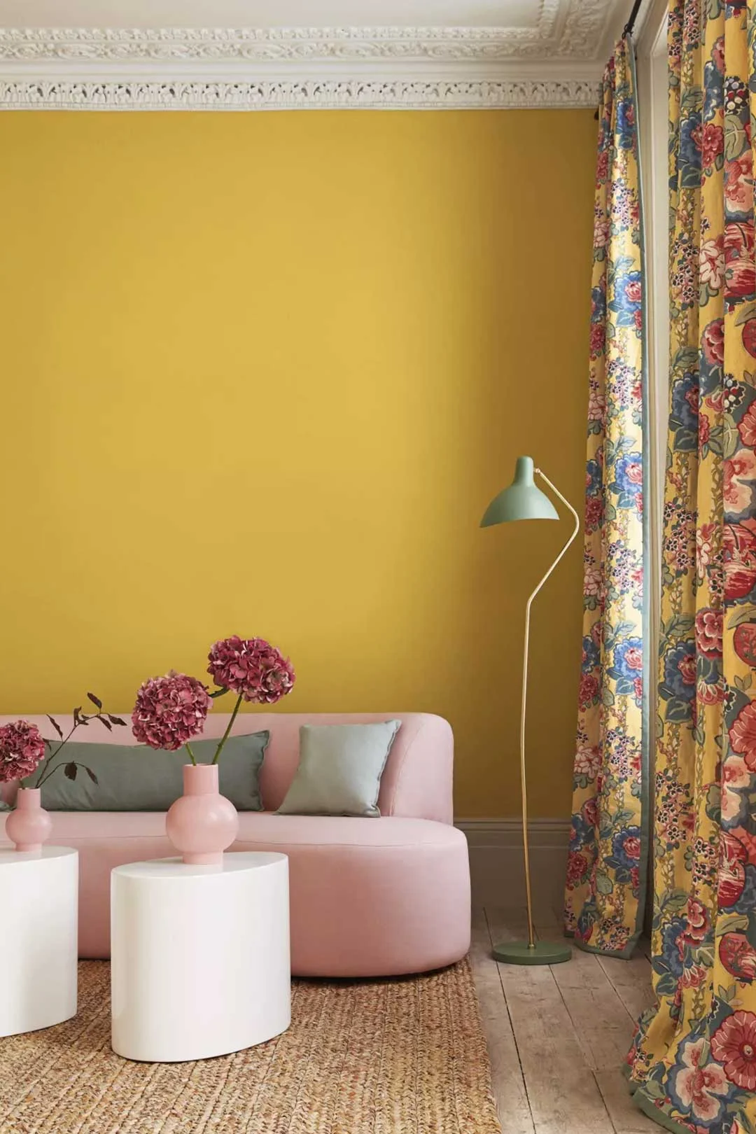 A bright colourful living room with colours matching the curtains taking on the Barbiecore trend