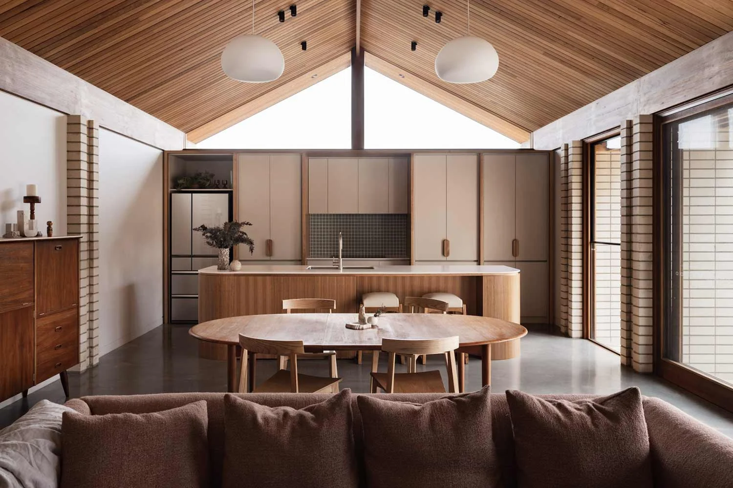 A kitchen renovation with a mid century modern colour palette of green and earthy tones and a strong use of timber cabinetry