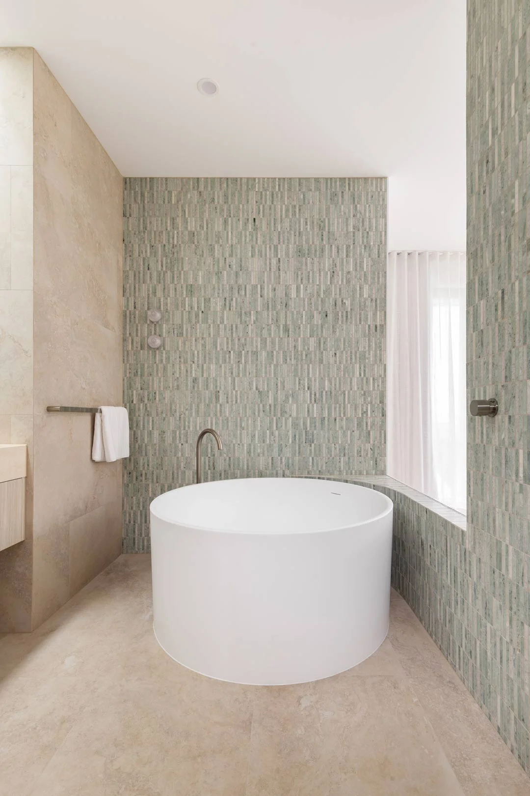 bathroom-with-green-marble-kitkat-tiles-round-bath-with-brushed-nickel-tapware