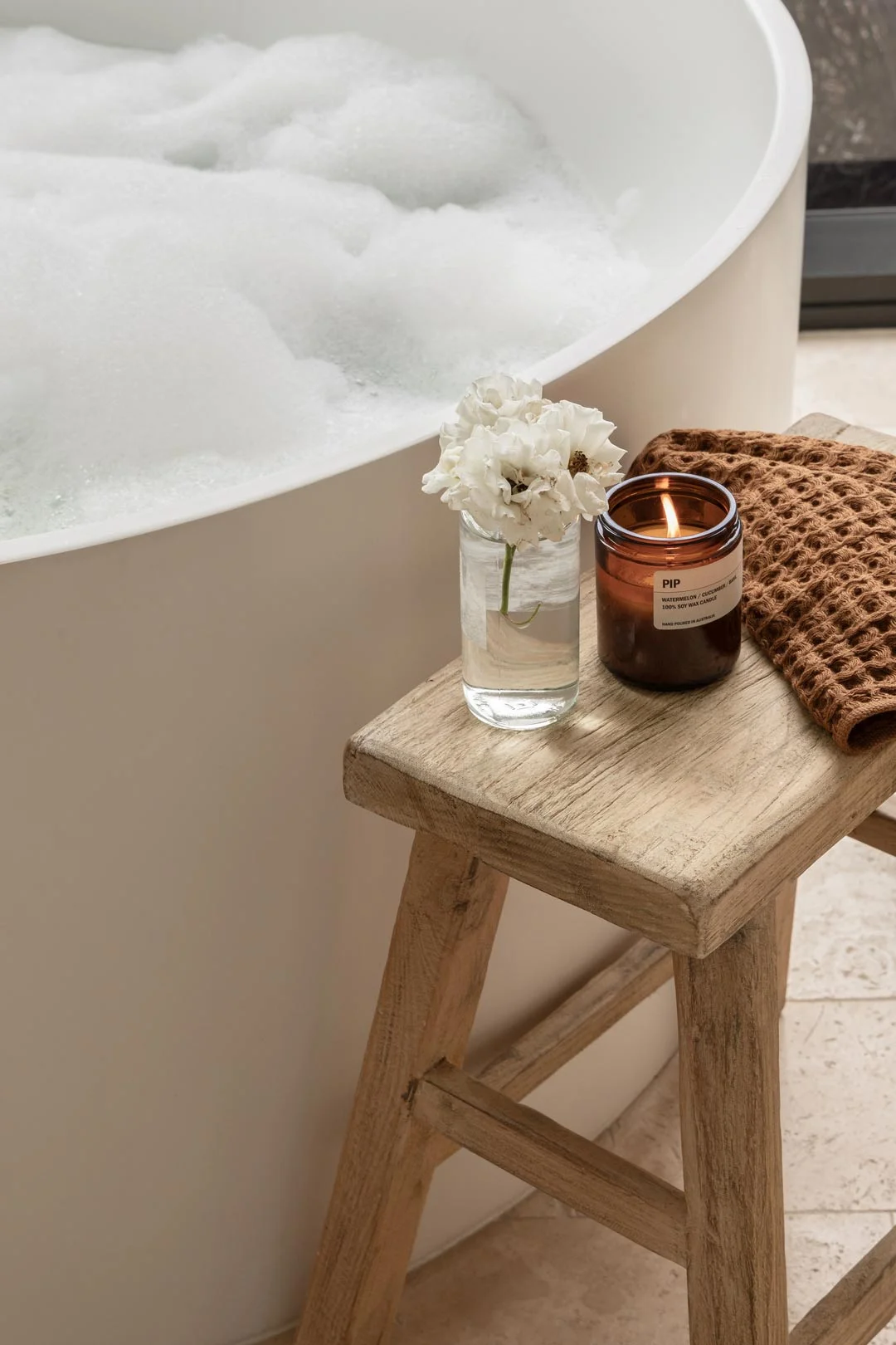 candle-and-flowers-on-stool-next-to-bath