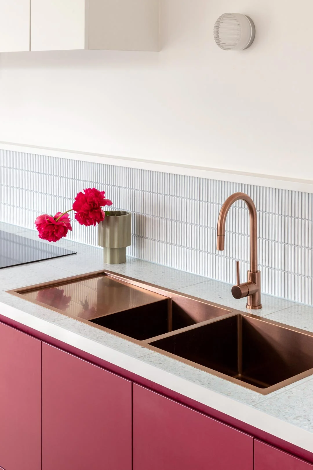 Magenta coloured cabinertry and brushed copper kitchen sink and mixer