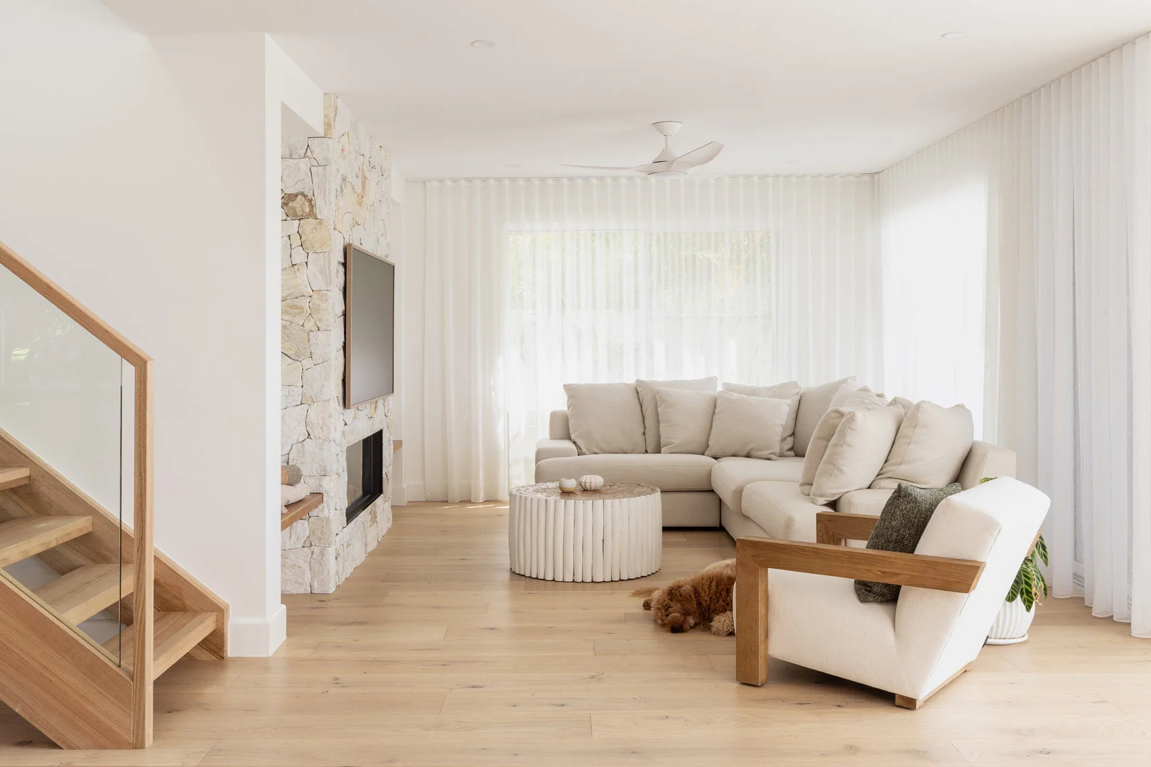 Property-Styling-Neutral-Living-Room-Stone-Fireplace-Timber-Floorboards-Cream-Couch-Sheer-Curtains