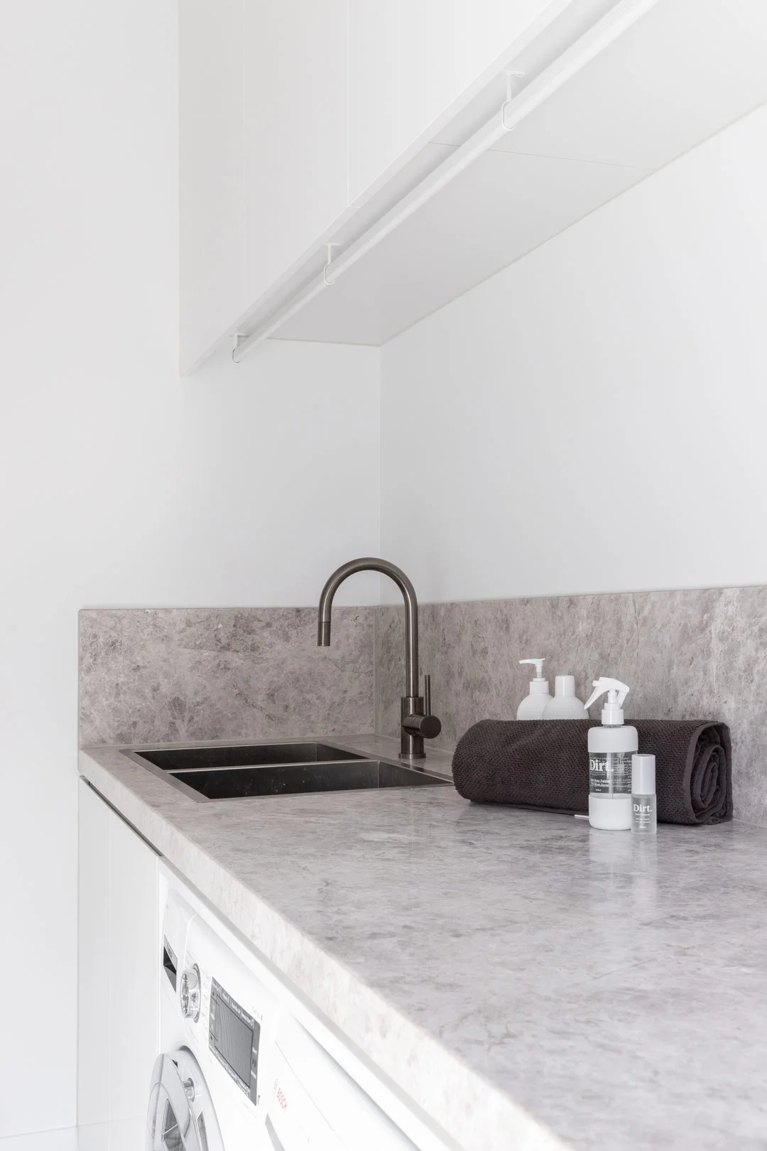 A brushed gunmetal double overmount sink with a matching mixer in a modern laundry