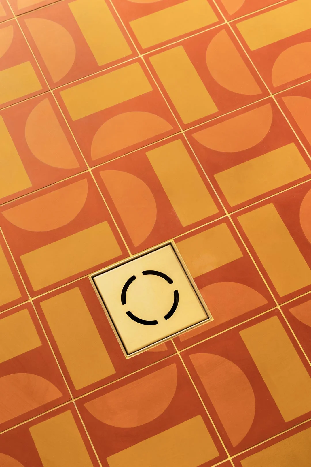 brass-floor-waste-with-bright-vibrant-square-floor-tile