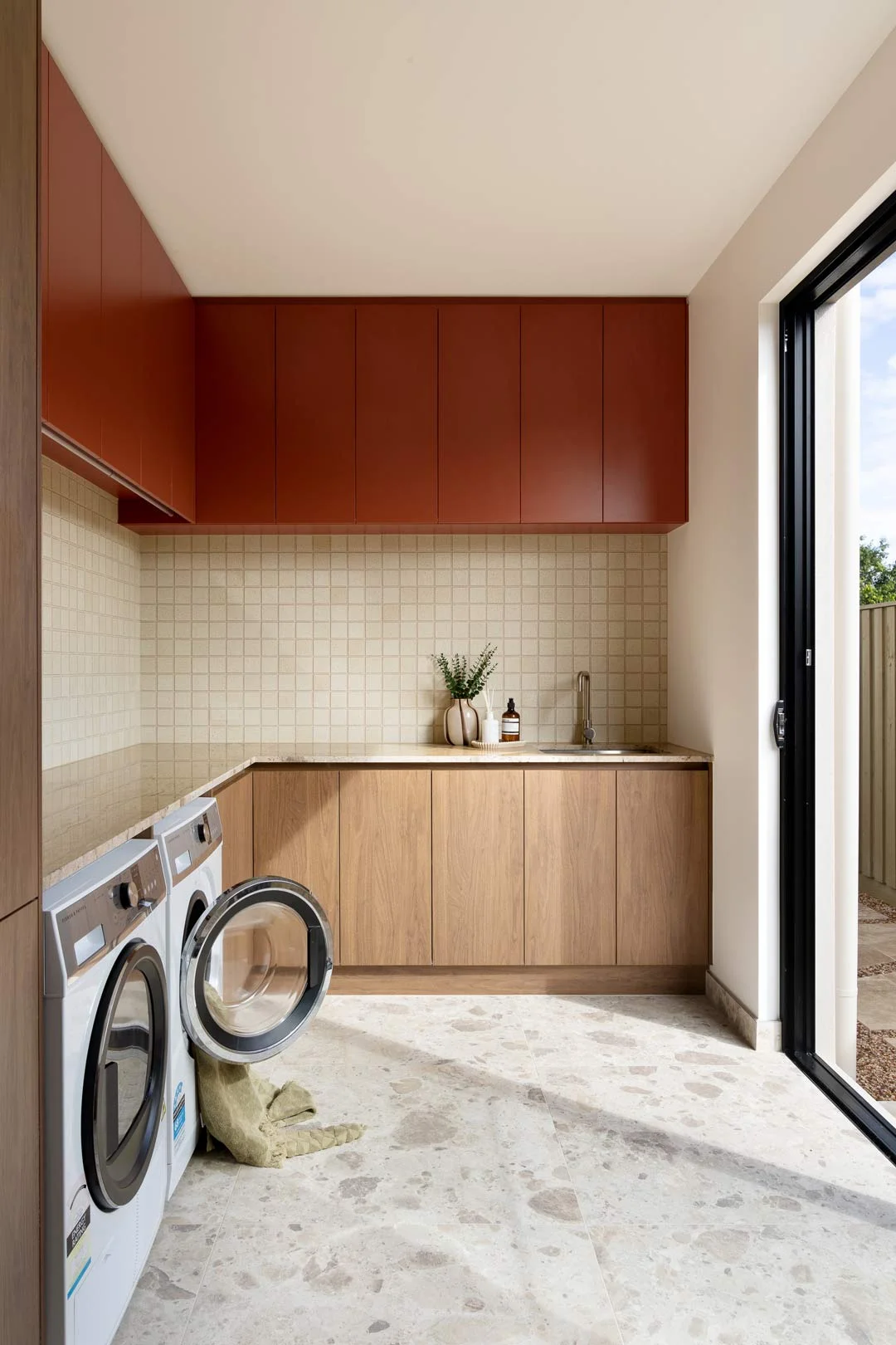 high-traffic-area-laundry-red-overhead-cabinetry-tarazzo-floor-tile