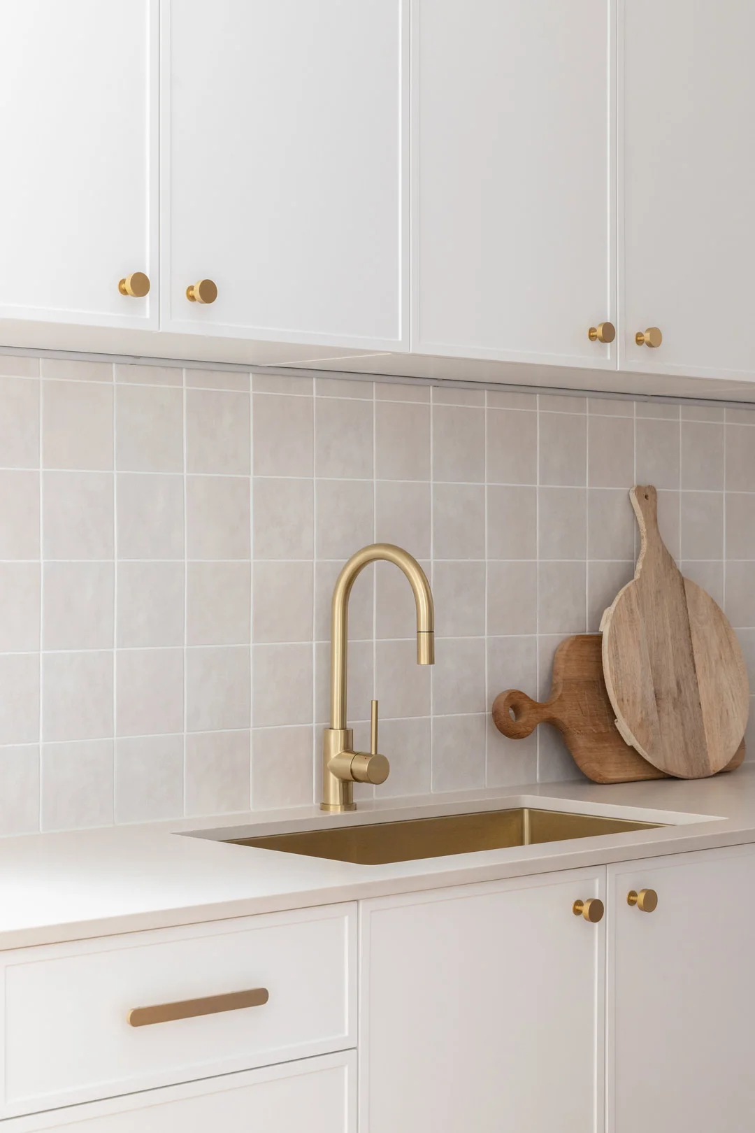 Brushed brass large undermount sink and matching mixer in a coastal kitchen