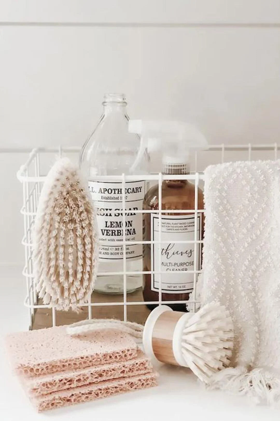 Under sink storage kept neat and tidy with labeled bottles and baskets