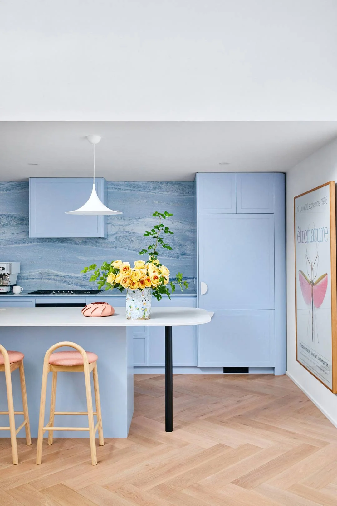 A blue kitchen with pink bench seats incorporating Barbiecore trend into your home