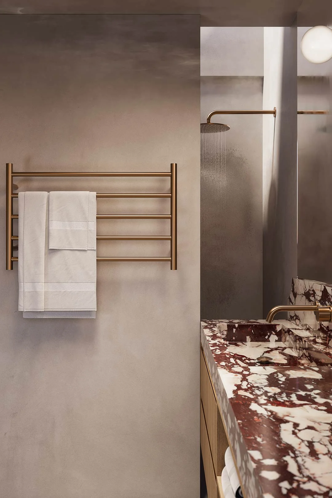 A brushed brass towel ladder in a moody bathroom is a great organisation idea