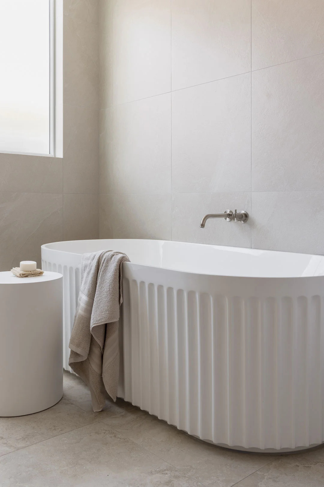 brushed-nickel-ribbed-tapware-with-white-fluted-bath-minimal-design