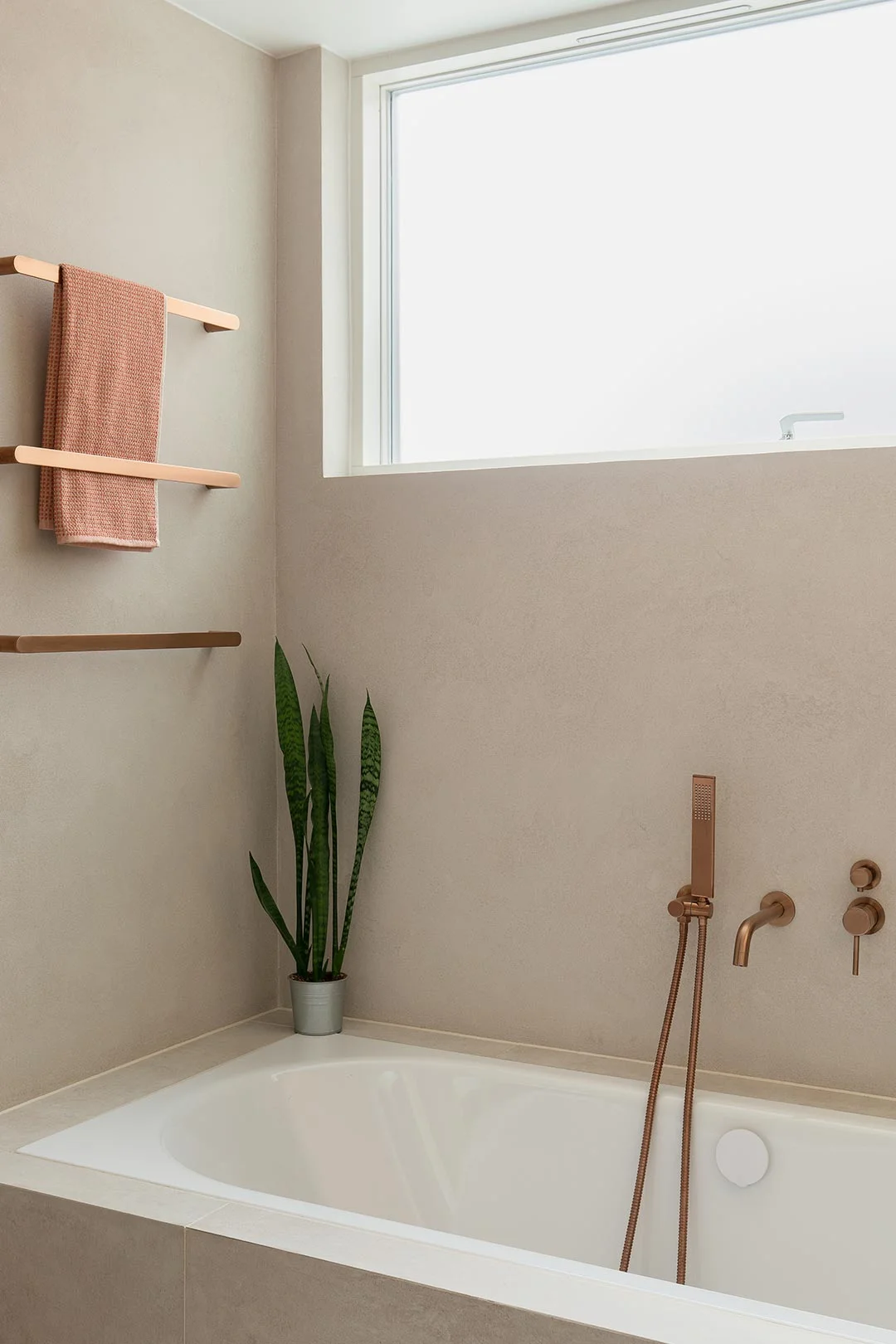 brushed-copper-tapware-over-inset-beige-tile-bath