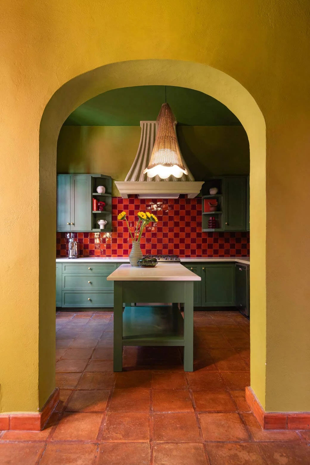 maximalist-decor-yellow-arch-way-into-kitchen-red-checker-tiles